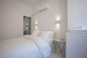 a white bedroom with a bed with white sheets and pillows at LUXE SUR LE PORT in Marseille +9 photos