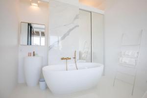 a white bathroom with a tub and a sink at LUXE SUR LE PORT in Marseille