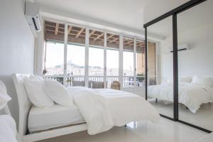 a white bedroom with a bed and a mirror at LUXE SUR LE PORT in Marseille