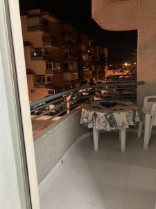 een tafel en banken op een balkon 's nachts bij APARTAMENTO LORE PLAYA in Santa Pola