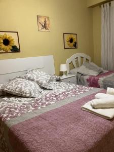 een slaapkamer met 2 bedden en een bloemrijk dekbed bij APARTAMENTO LORE PLAYA in Santa Pola