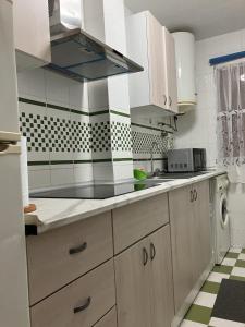 een keuken met witte kasten en zwarte en witte tegels bij APARTAMENTO LORE PLAYA in Santa Pola