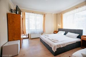 1 dormitorio con cama y ventana grande en Pensiunea Viktoria, en Băile Tuşnad