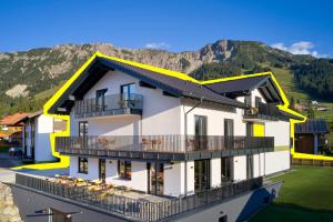 a rendering of a building with mountains in the background at BergBuddies Oberjoch in Bad Hindelang