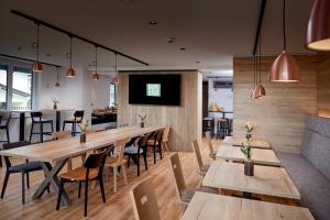 une salle à manger avec des tables et des chaises en bois dans l'établissement BergBuddies - Übernachtung inklusive kostenlosen Bergbahntickets und vielem mehr, à Bad Hindelang