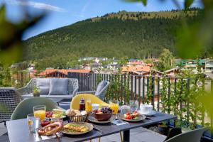 un tavolo con cibo e bevande su un balcone di BergBuddies - Übernachtung inklusive kostenlosen Bergbahntickets und vielem mehr a Bad Hindelang