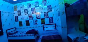 a bedroom with a wall with posters on it at Blue eye Backpackers Hostel in Amritsar