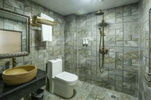 y baño con aseo, lavabo y ducha. en Mountain View Guesthouse, en Zhangjiajie