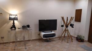 Il comprend un salon doté d'une télévision à écran plat et d'une table. dans l'établissement Ospitalità e Fotografia, à Agliana