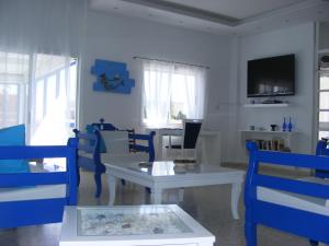 a living room with blue chairs and a white table at Flokkas Hotel Apartments in Protaras