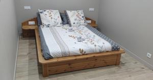 a wooden bed with pillows on it in a room at La petite châtaigne in Valdeblore
