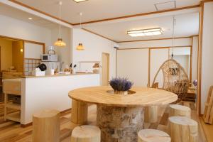 a kitchen and dining room with a wooden table and stools at ヴァンテアン舎（vingt et un house） in Biei