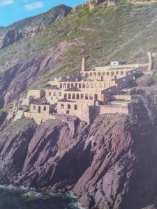 a building on the side of a mountain at Sardinia Experience in Villamassargia