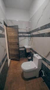 een badkamer met een toilet en een wastafel bij Bliss Beach Villa in Alleppey