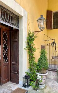 un bâtiment avec une porte, des plantes et une lanterne dans l'établissement Villa Leopardi, à Vignale