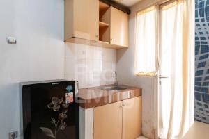 a small kitchen with a sink and a refrigerator at RedLiving Apartemen Green Lake View Ciputat - Aurora Rooms in Pondokcabe Hilir