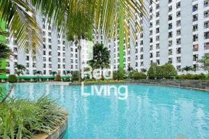 una grande piscina di fronte a un grande edificio di RedLiving Apartemen Green Lake View Ciputat - Aurora Rooms a Pondokcabe Hilir