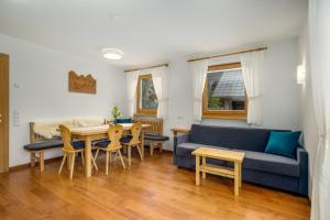 uma sala de estar com um sofá azul e uma mesa em Ferienwohnung Mair am Bach em Brunico