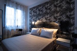 - une chambre avec un grand lit et un mur noir et blanc dans l'établissement Ospitalità e Fotografia, à Agliana
