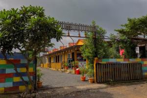 Mandav Hills Resort & Film City في Māndu: صف من المنازل مع جدران ملونة وسياج