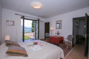 a hotel room with a bed and a balcony at Villa Blu Ortensia - Happy Rentals in Pura