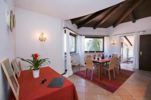 una sala da pranzo con tavolo e sedie rossi di Villa Blu Ortensia - Happy Rentals a Pura
