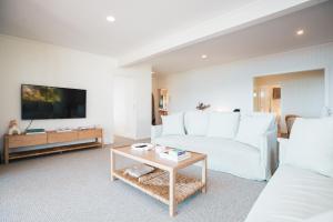 a living room with a white couch and a table at Wategos Villa in Byron Bay