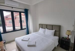 a bedroom with a large white bed with a window at ChanthaSouk Vang Vieng Entire Villa in Vang Vieng