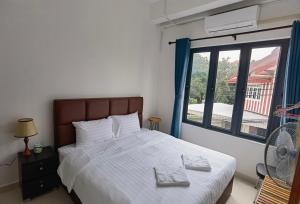 a bedroom with a bed and a large window at ChanthaSouk Vang Vieng Entire Villa in Vang Vieng