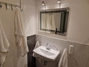 Un baño con lavabo, espejo y toallas. en Capital Apartments, en Düren - Eifel 35 fotos más