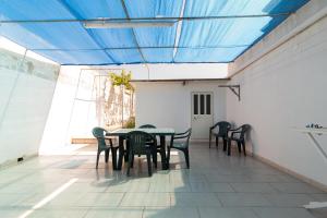 トッレ・サン・ジョヴァンニ・ウジェントにあるThe Green Sea Small Houseの青い天井の客室で、テーブルと椅子が備わります。
