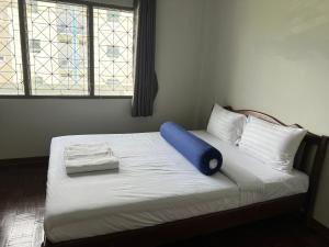 a bed with a blue pillow on top of it at Piano Private House in Ban Kohong