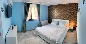 1 dormitorio con cama blanca y ventana en Casa Dana Scorțeni, 