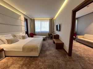 una camera d'albergo con letto e divano di Hotel Mepas a Mostar