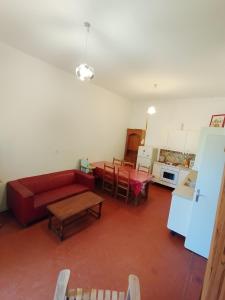 ein Wohnzimmer mit einem roten Sofa und einem Tisch in der Unterkunft Le Grand Saint Mitre in Saint-Maximin-la-Sainte-Baume