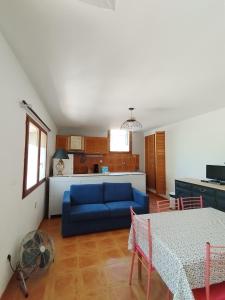 ein Wohnzimmer mit einem blauen Sofa und einer Küche in der Unterkunft Le Grand Saint Mitre in Saint-Maximin-la-Sainte-Baume