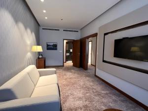 sala de estar con sofá blanco y TV de pantalla plana en Hotel Mepas, en Mostar