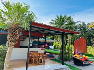 a house with a gazebo and a palm tree at บ้านโกจุยรีสอร์ต in Ban Ratchaphruk