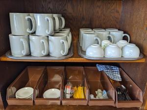 two shelves with cups and saucers on them at City Pension Zem in Tokyo