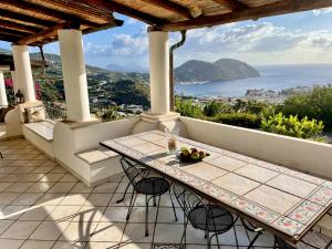 a table on a balcony with a view of the ocean at Villa 'A Pisa in Lipari