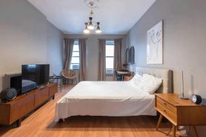 a bedroom with a bed and a flat screen tv at Lovely Studio in Heart of NYC (Midtown West) in New York