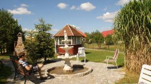 a young boy sitting in a chair next to a fountain at Niebo nad Łysicą in Święta Katarzyna