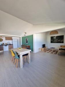 Großes Zimmer mit einem Holztisch und Stühlen. in der Unterkunft Caz' Mamie in Gôl