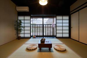 un soggiorno con tavolo e 2 pouf di おやど紀伊国屋 丸山町 庭 a Nagasaki