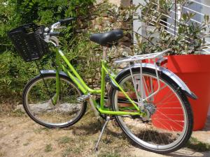 een groene fiets geparkeerd naast een gebouw bij Hôtel L'Escale in L'Ile d'Yeu