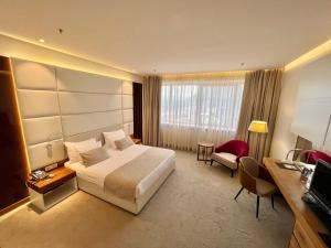 モスタルにあるホテル　メパスの大きなベッドとデスクが備わるホテルルームです。