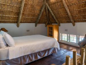 1 dormitorio con 1 cama en una habitación con suelo de madera en Klipdrift Sands Bush Camp, en Dinokeng Game Reserve