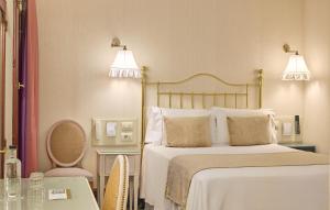 a bedroom with a bed with two lamps and a table at Hotel Continental Palacete in Barcelona