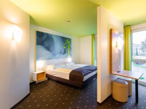 ein Hotelzimmer mit einem Bett und einem Fenster in der Unterkunft B&B Hotel Krefeld in Krefeld