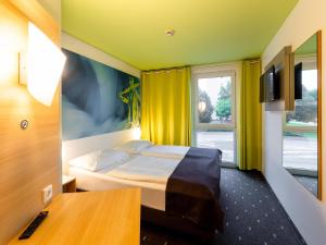 ein Hotelzimmer mit einem Bett und einem Fenster in der Unterkunft B&B Hotel Krefeld in Krefeld